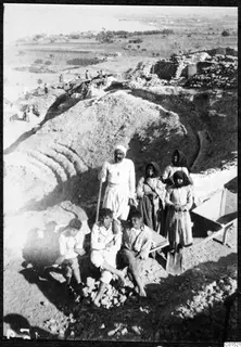 Work group of an older man, three young men and three women at the excavation of Soli, with a wheelbarrow and spoil heap
