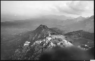 Rocky ridge in the Kyrenia Mountains looking over a hazy plain toward water and distant mountains