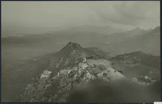 View over rocky hilltops and scrubby slopes in the Kyrenia Mountains, with a hazy plain and water on the left