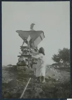Praxou loading earth into a wooden hopper frame on a stone base at Vouni
