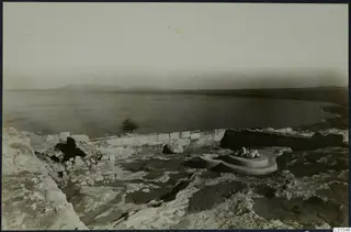 Ruined stone wall and a circular stepped base in the foreground, with the sea beyond, at Vouni palace