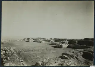 Ruined stone walls and bare excavated ground at Vouni palace, with the sea on the left horizon
