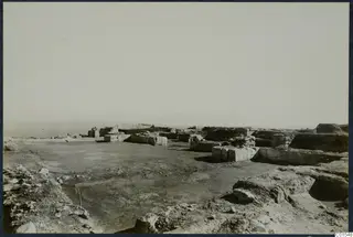 Ruined stone walls and rock outcrops at the Vouni palace site, with the sea and a distant headland beyond