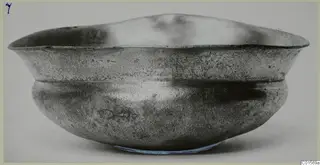 Silver bowl with a flared rim and rounded body, photographed from the side against a plain pale background.