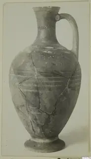 Pottery jug with a tall neck, single strap handle and horizontal painted bands, reconstructed from fragments