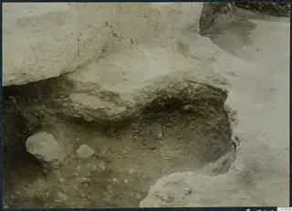 Excavated cutting at Vouni palace with a large stone block and loose stones in the soil