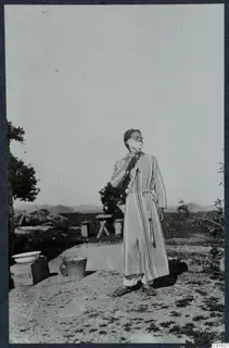 Alfred Westholm shaving outdoors at Vouni, wearing a striped housecoat with lather on his face.
