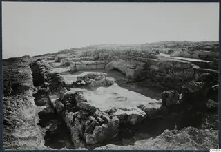 Excavated stone walls and foundations at the palace at Vouni, seen from a raised viewpoint.
