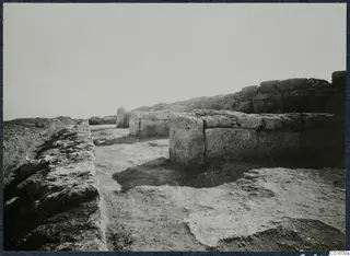 Excavated stone walls and a cleared floor at the palace at Vouni, seen from a trench edge.