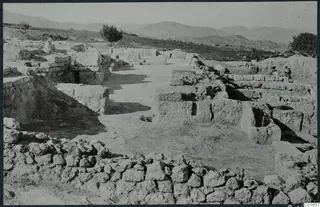 Excavated walls at the palace at Vouni, with a person standing beside a wall at right