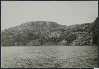 Rocky hill rising above the sea at Vouni, seen from the water