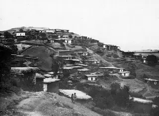 Hillside village of Galini with flat-roofed stone and whitewashed houses, and two small children on a dirt path
