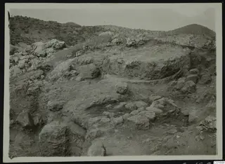 Excavated slope at Petra tou Limniti with large stones and exposed earth below dry hills.