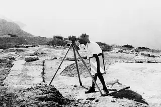 Alfred Westholm sighting through a levelling instrument on a tripod at Vouni