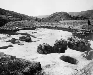 Excavated area at Ayios Iakovos with stone walls, a deep pit and a large sunk vessel, seen from the east
