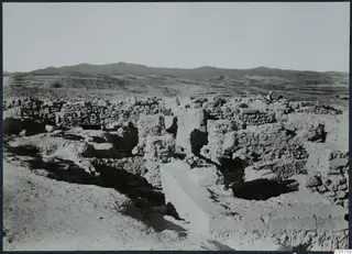 Excavated stone walls and foundations at Idalion, with hills behind the ruins.