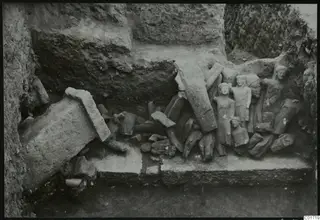 Statues lying in situ among fallen stone blocks in the Kition cult room