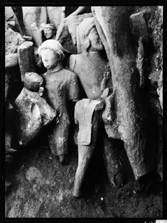 Carved stone statues standing in situ among rubble and fallen blocks in the cult room at Kition.