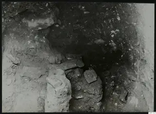 Sculpted head and stone blocks in situ in the cult room, north gallery, at Kition