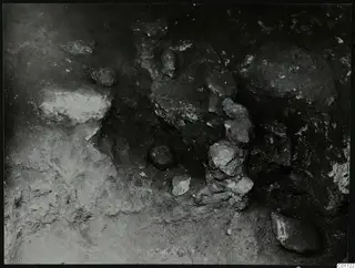 Excavated area at Kition with stones and rounded forms lying in situ in the soil