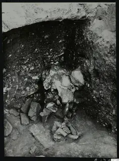 Excavated recess at Kition with stones and broken fragments in situ, with possible bones at the lower centre