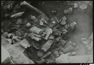 Cult room deposit at Kition: broken stone sculpture fragments lying in excavated soil