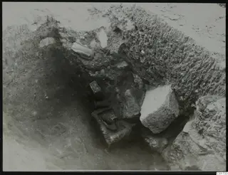 Excavation pit at Kition with stone pieces lying in situ against the cut earth walls.