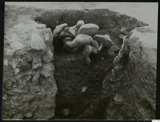 Central pit at Kition with large stone sculpture fragments lying in situ among excavated rock