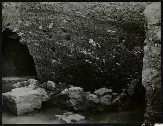 Soil section in the cult room at Kition, with a recess at left and stones and a cut block in front
