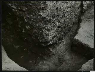 Close view of a rough stone face and soil floor in an excavation trench by the north gallery at Kition