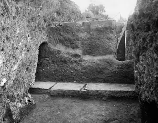 Excavation at Kition showing the large profile wall of earth inside the cult room, with stone slabs at its base