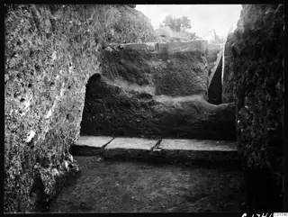 Excavated trench at Kition with a large vertical profile wall and flat stone slabs across its base