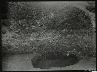 Vertical section of excavated soil at the Bamboula, Kition, with stones in the layers and a hollow cut at its base.