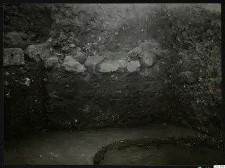 Soil profile in the eastern part of the Bamboula at Kition, showing layers of earth and scattered stones.