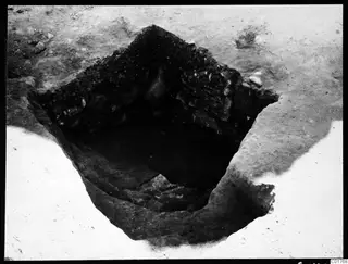 Angular profile in the central pit at Kition, Larnaca, with stones set in the dark soil of the pit walls