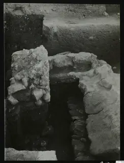 Stone walls and a narrow passage in an excavated area at Kition, seen from above.
