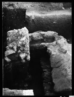 Excavated stone walling and rubble in a trench at Kition, below the central pit