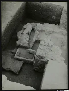 Excavation trench at Kition, Larnaca, with a carved stone slab set in a rectangular stone frame among fallen stones