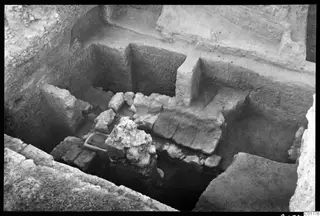 Excavated trench at Kition showing stone walls and a rough stone block in the foreground, seen from the north.