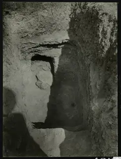 Tomb 7 at Kountoura Trachonia, seen from outside as a cut opening in a bank of earth with a stone block beside it