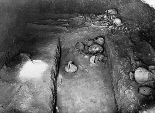 Interior of Tomb 7 at Kountoura Trachonia, with skeletal remains and pottery vessels on the floor
