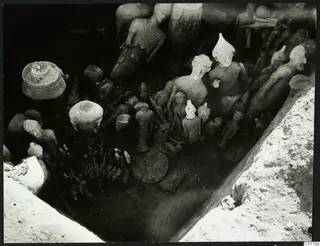 Sculptures and vessels lying in situ in an excavated trench at Ayia Irini