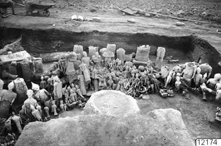 Overall view of the Ayia Irini excavation, with many statues, heads and small figures laid out in a trench