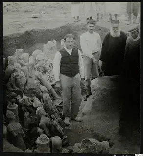 Men standing beside a trench at Ayia Irini filled with figurines and vessels laid out in the ground