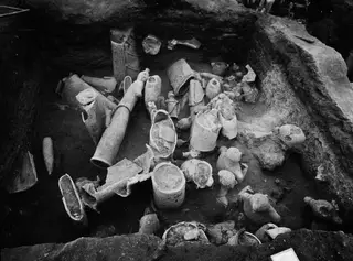 Grid square K 10 at Ayia Irini with broken terracotta figurines and vessels lying in the excavated soil.