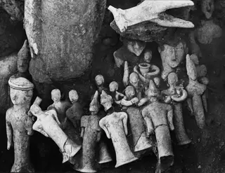 Clay figurines lying in a cluster in the ground in Square L 9-10 at Ayia Irini