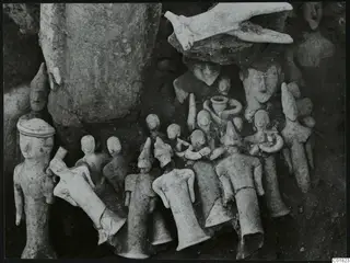 Clay figurines and a bird-shaped object lying together in the soil at Ayia Irini, Square L 9-10.