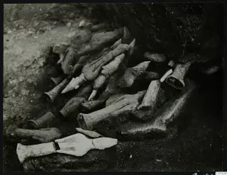 Figurine fragments, arms, legs and hands, lying half-buried in soil at Ayia Irini as found during excavation