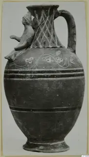 Painted jug with a modelled head on the shoulder and a loop handle, from Marion.