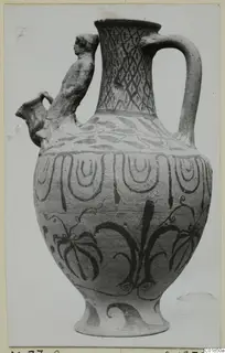 Pottery White Painted VII jug with a modelled human figure rising from the shoulder beside the spout